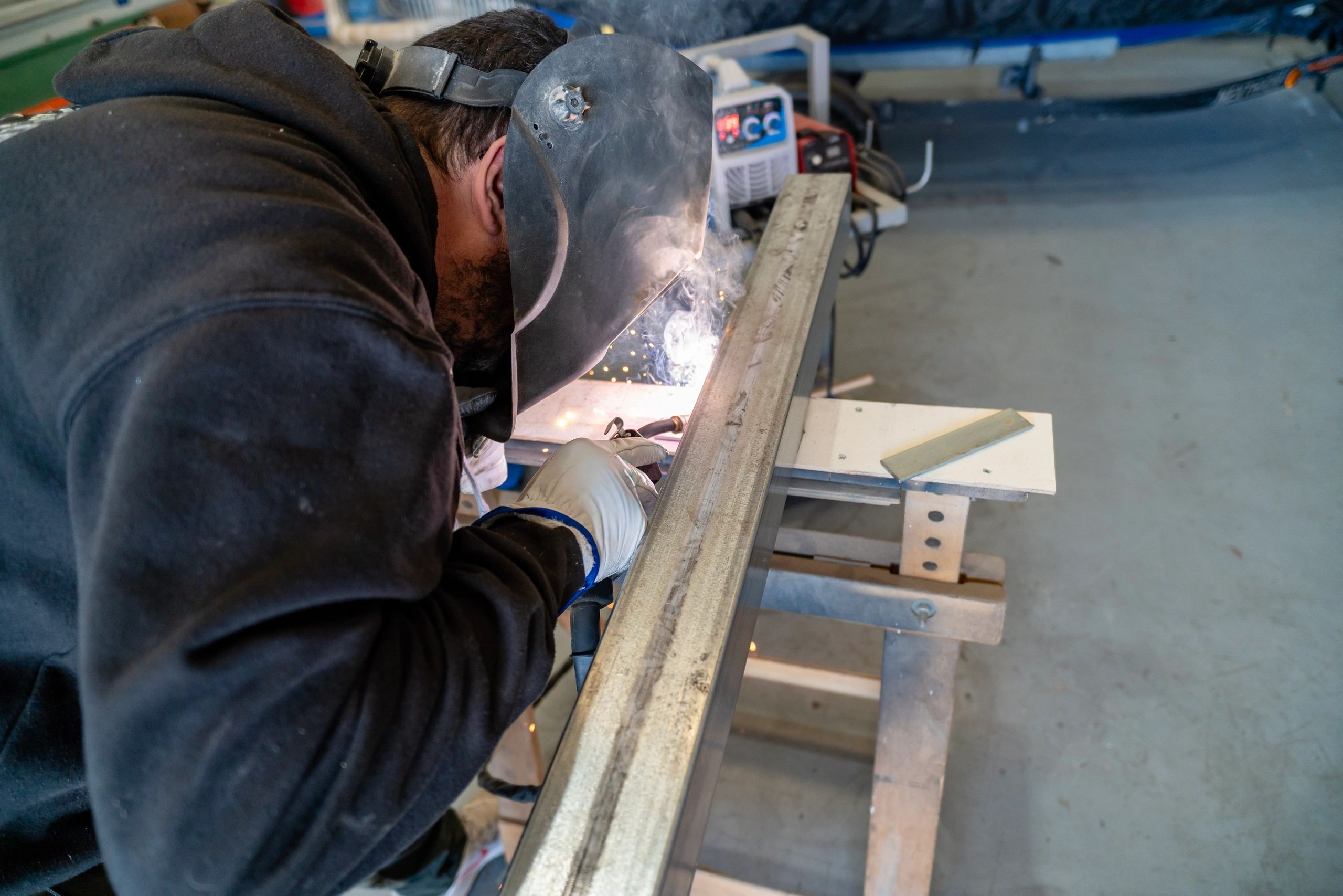 Welder working on a steel beam with sparks