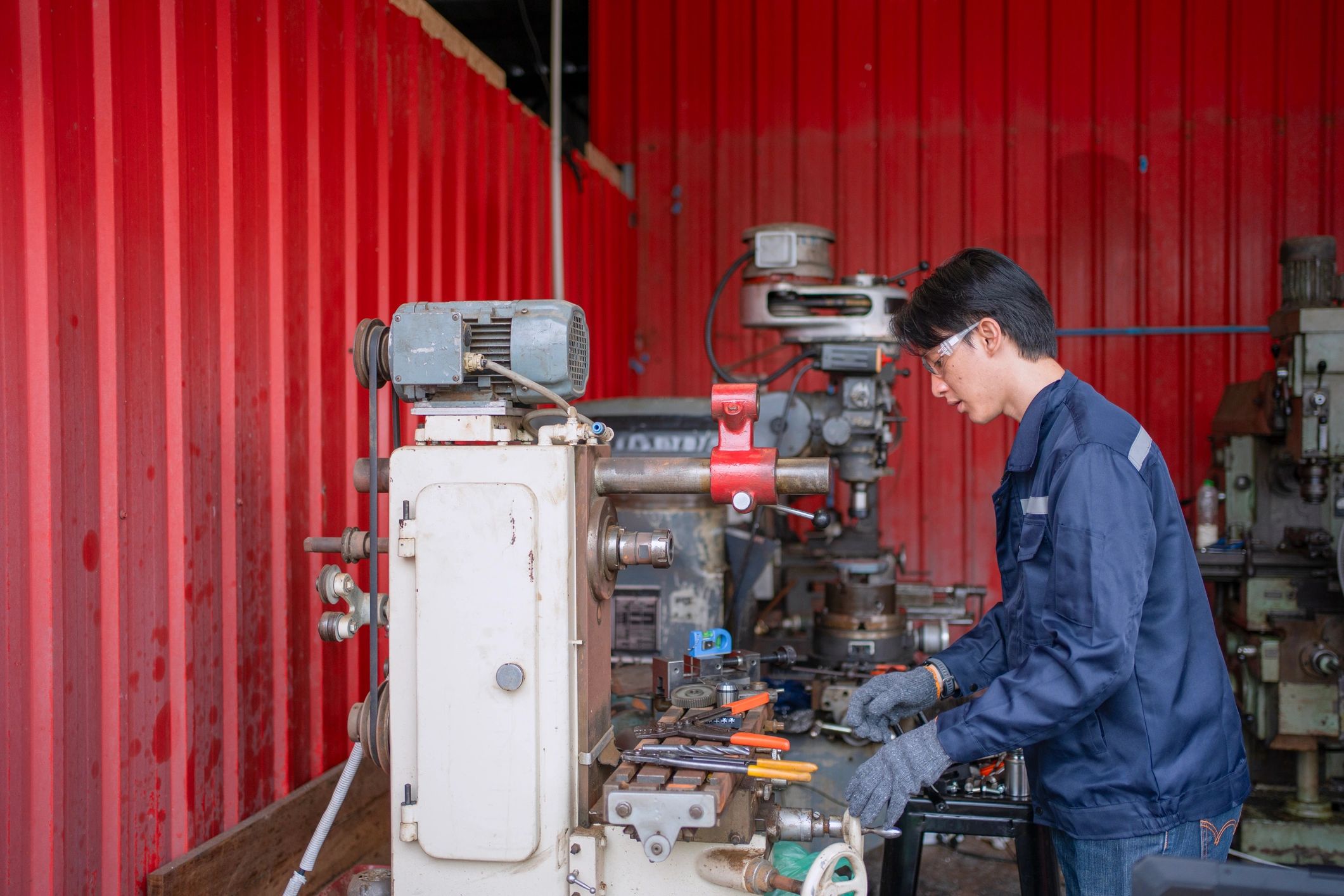 Steel fabrication shop worker at machine in a metalworking facility