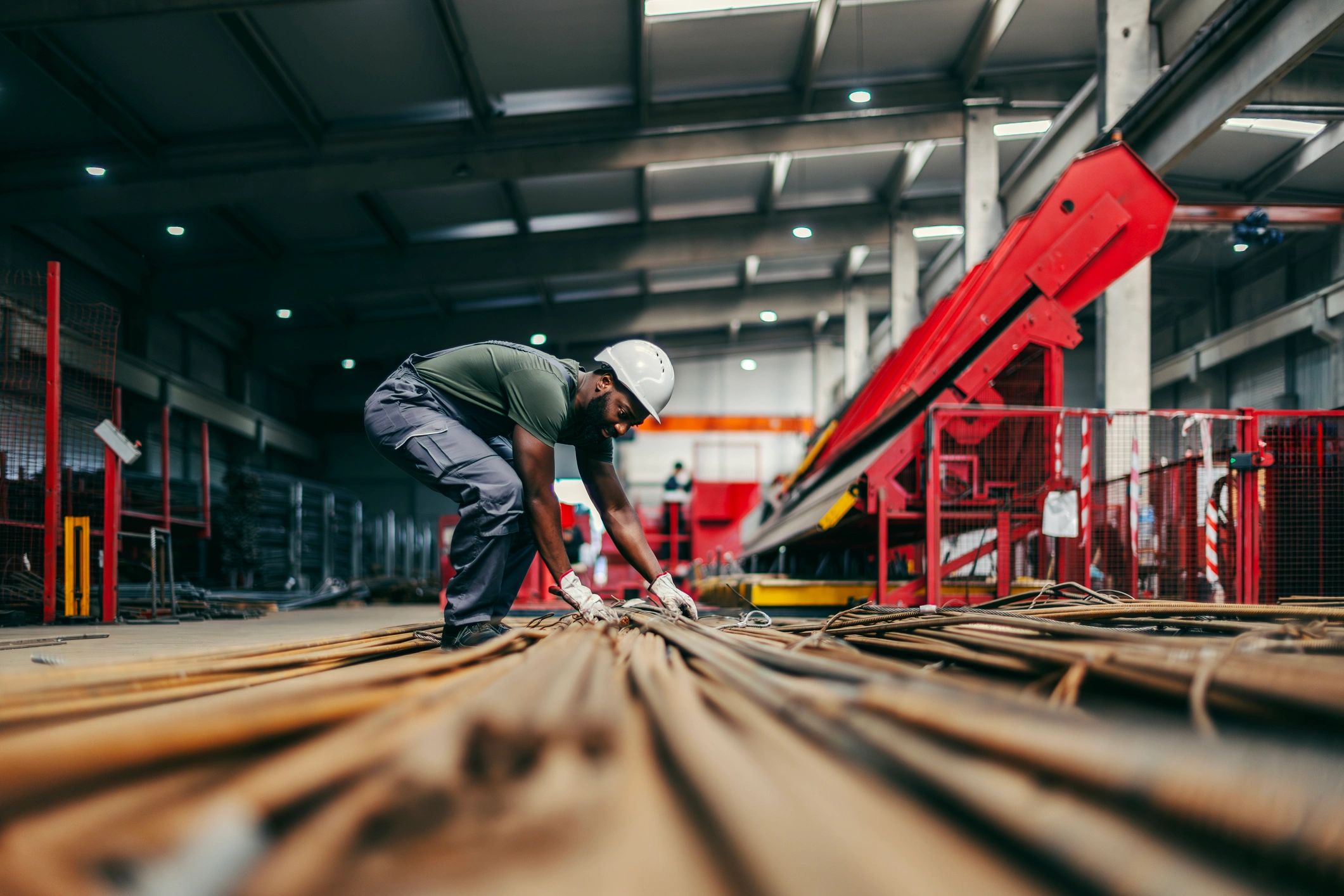 Steel fabrication worker handling material in an industrial shop